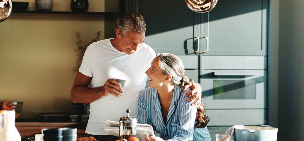 Retired couple at a kitchen counter.